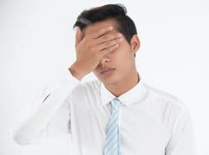 Face of worried young businessman making mistake